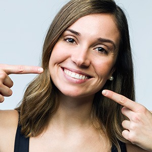 Woman pointing to her smile