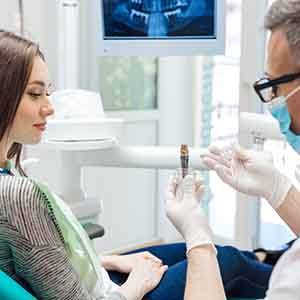 a dentist explaining how dental implants work to a patient