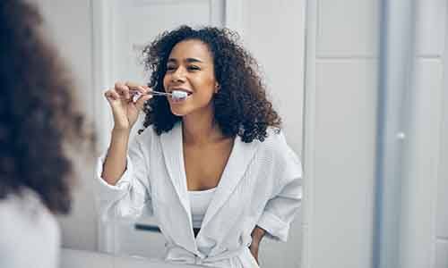 a woman brushing her teeth in a bathroom